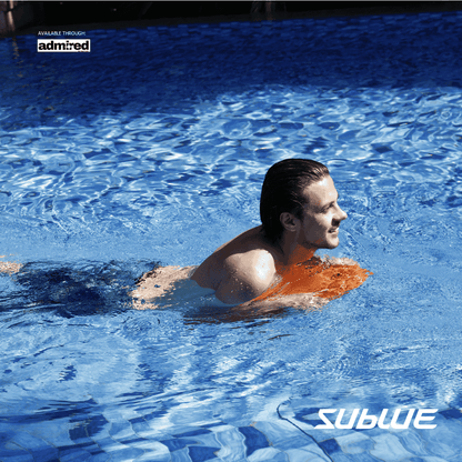 Boy holding orange SUBLUE Swii Electronic Kickboard at poolside, ready for fun.