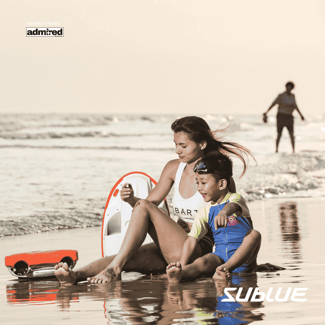 Woman and child on the beach with SUBLUE Swii kickboard, enjoying water fun.