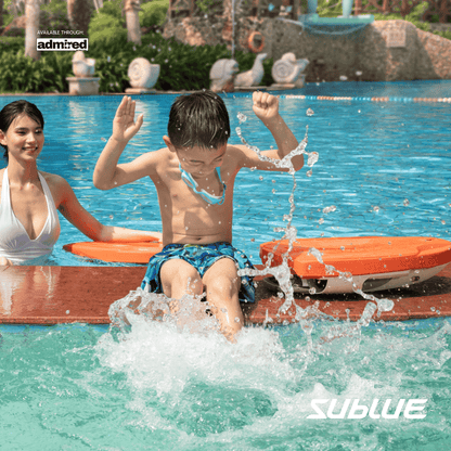 Child jumping into the pool with SUBLUE Swii kickboard and adult nearby.