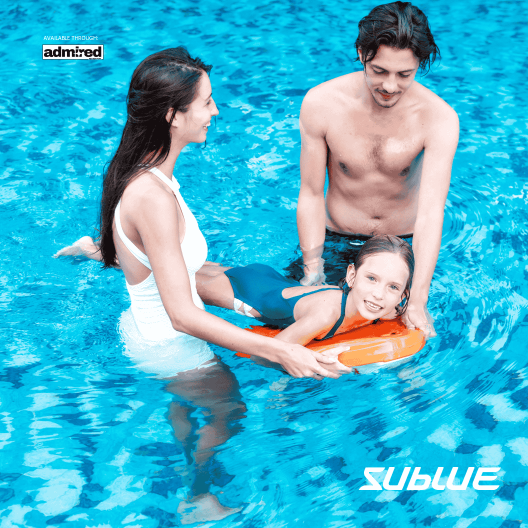 Child supported by adults in a pool, using SUBLUE Swii kickboard for swimming.