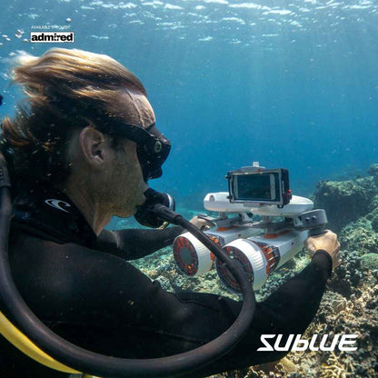 A person in a scuba gear holding a camera using Sublue Tini underwater