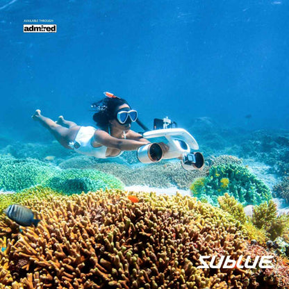 Diver using SUBLUE MixPro underwater scooter near vibrant coral reef.