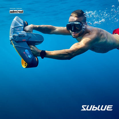 Diver in red shorts using SUBLUE Navbow+ underwater scooter in clear blue water.